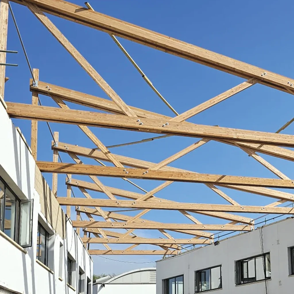 Wooden roof beams being installed with blue sky background